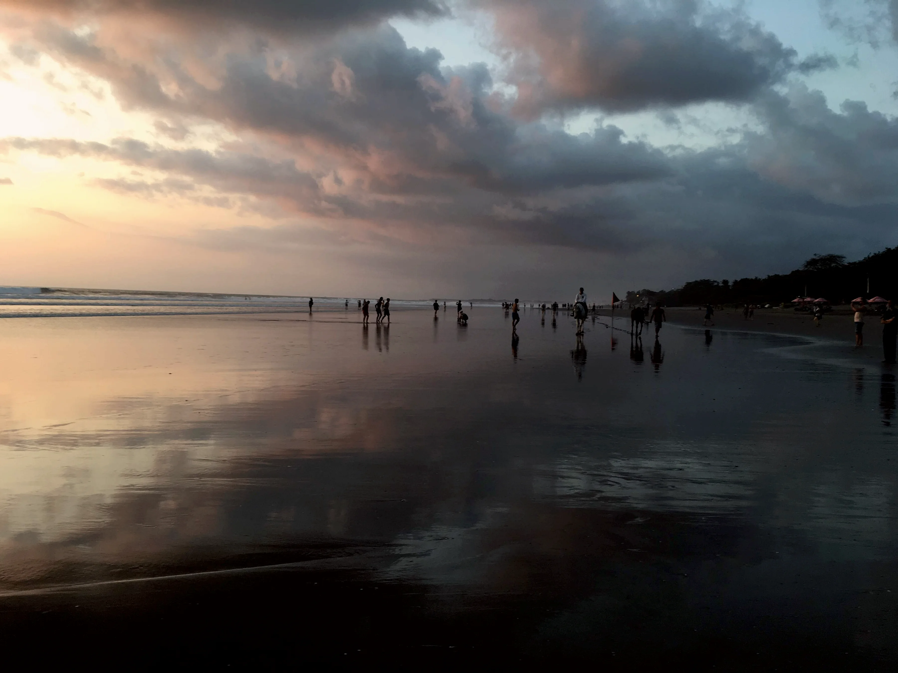 Wet sand mirroring the evening sky on Seminyak beach