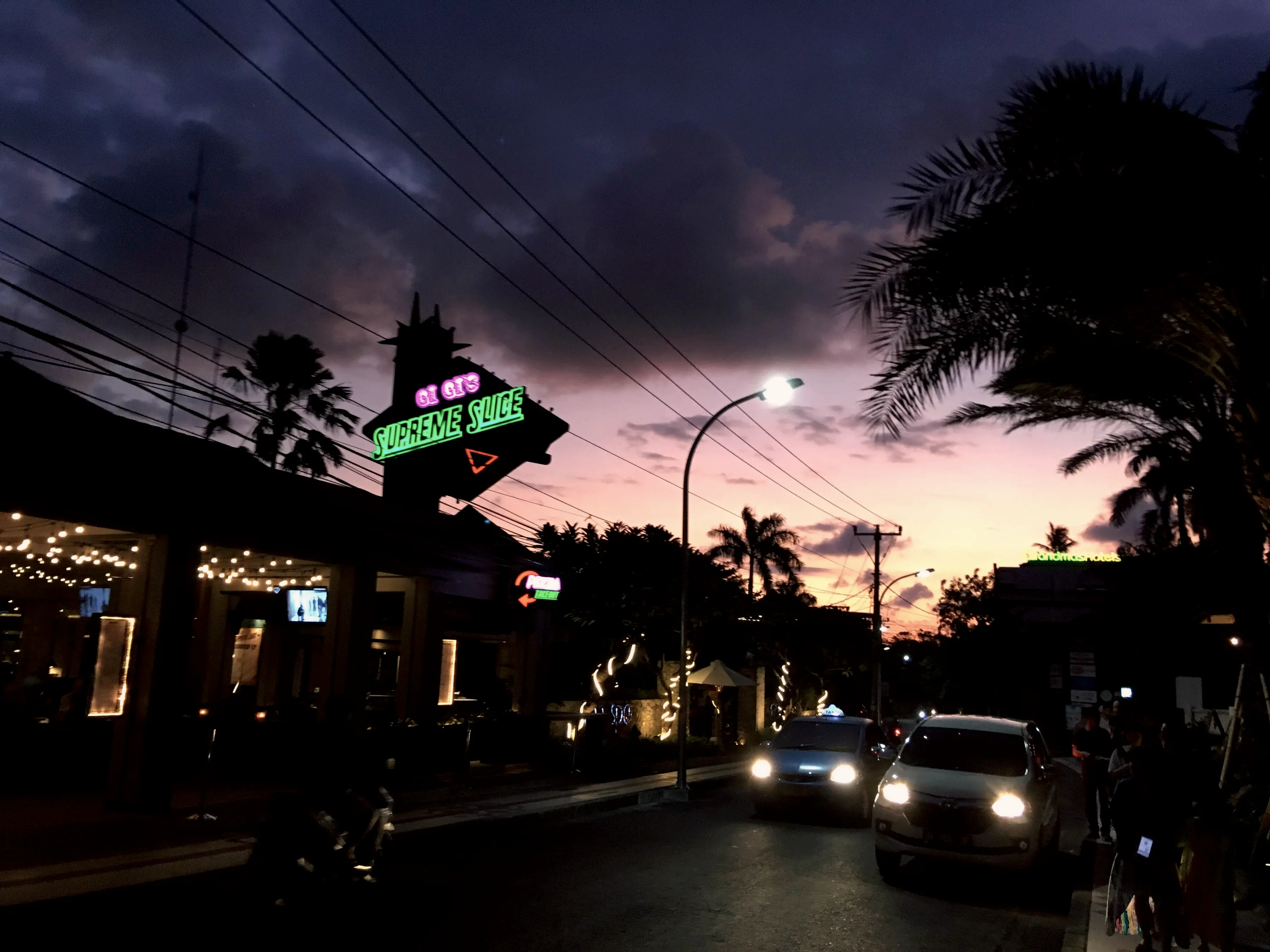 A Seminyak street at dusk as the shop lights come on