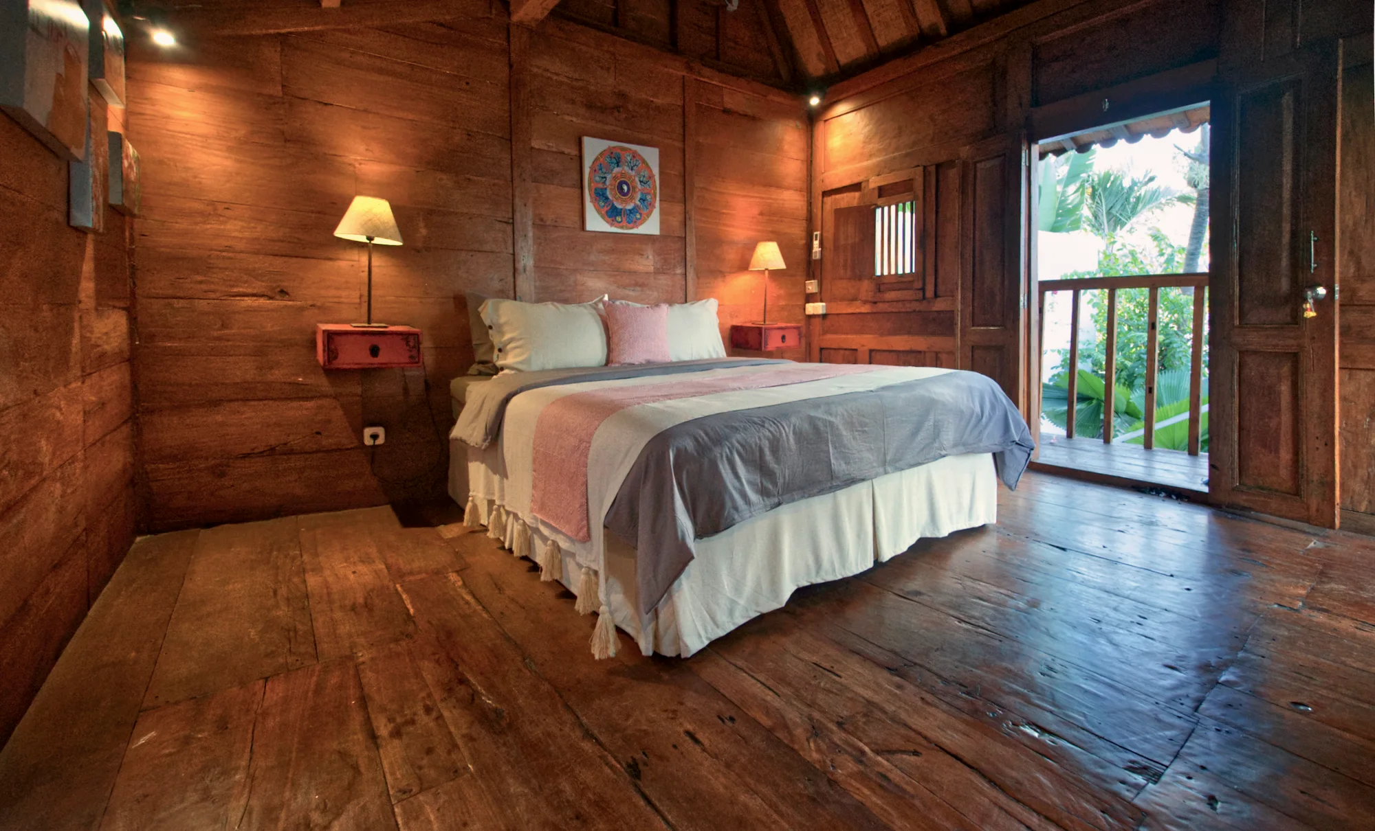 A Joglo bedroom with two reading lamps and a shuttered window