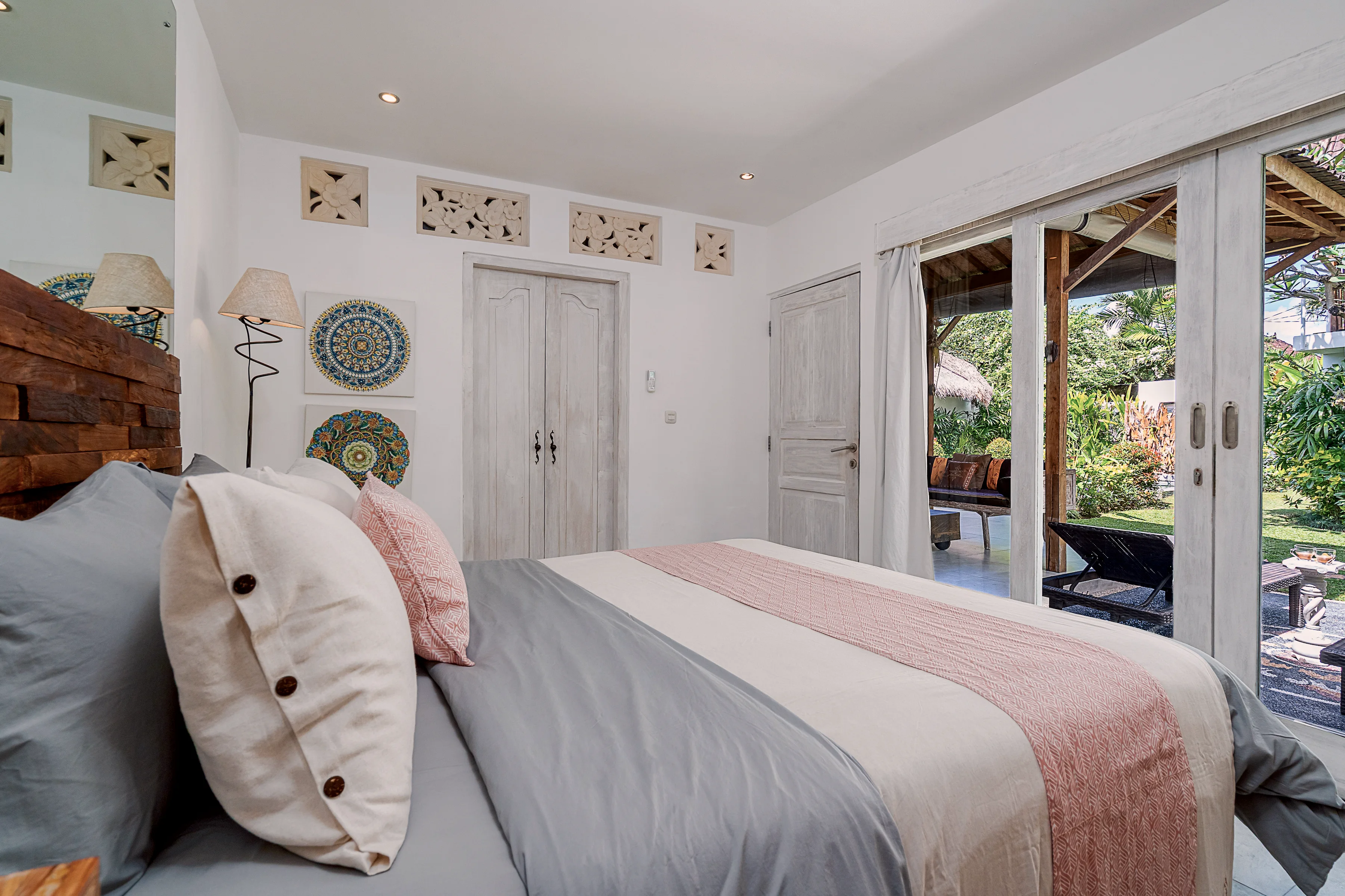 The bed beside glass doors open to the garden