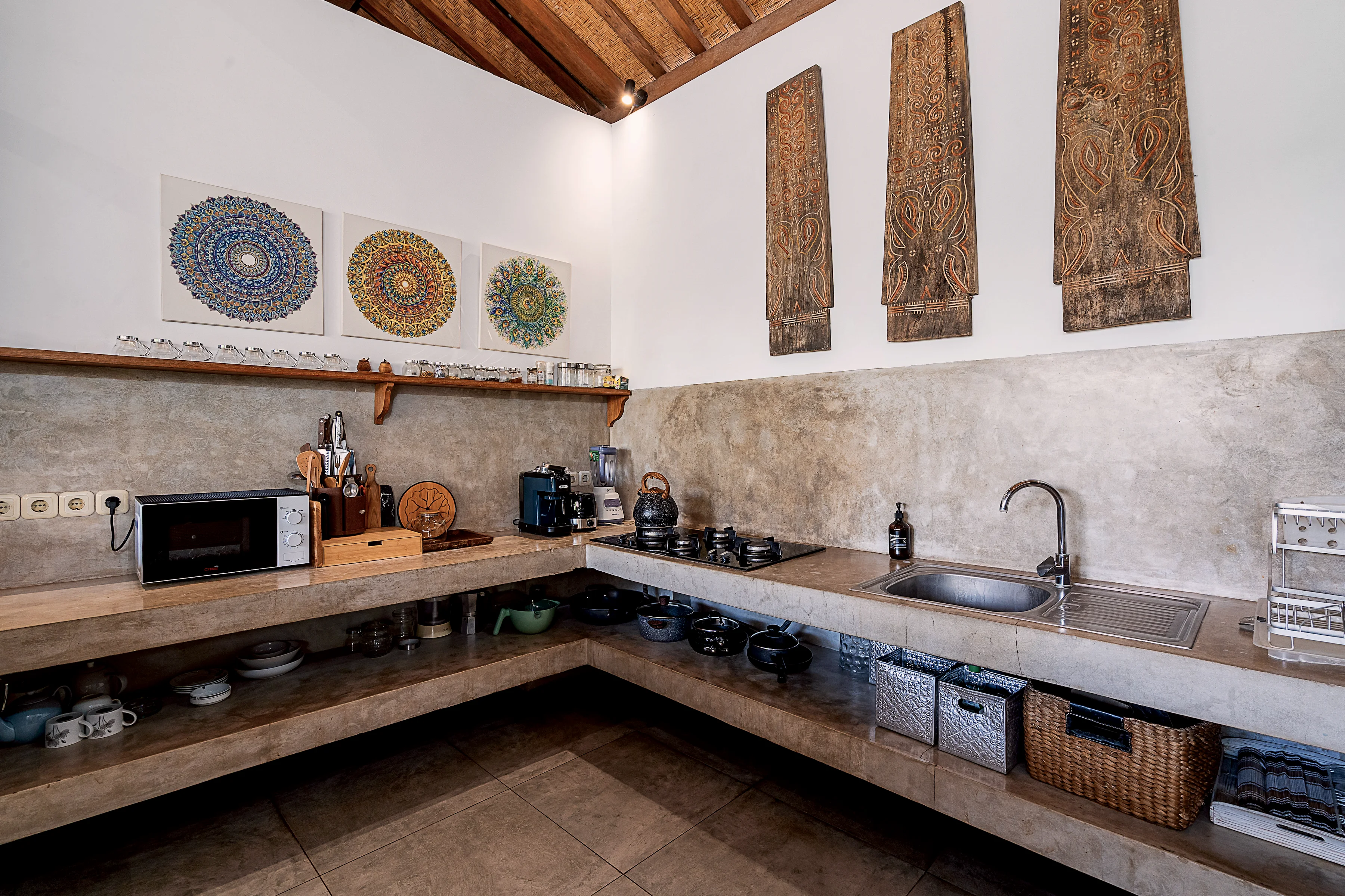 The kitchen: concrete counters, open shelves and painted plates on the wall