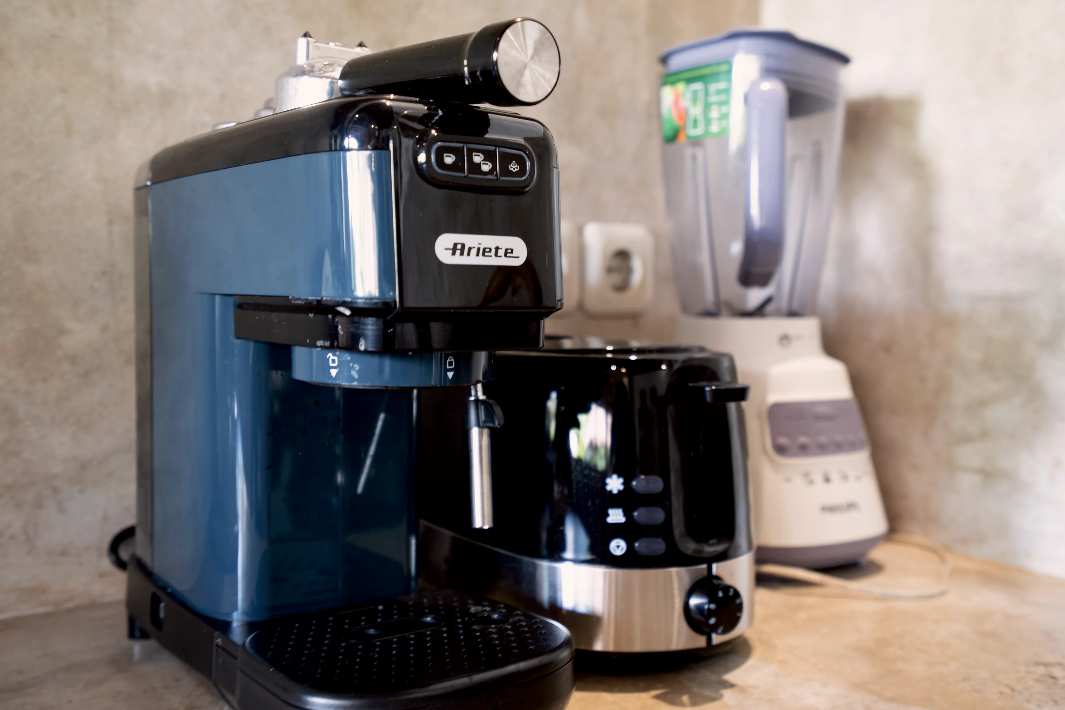 An espresso machine, a toaster and a blender on the kitchen counter