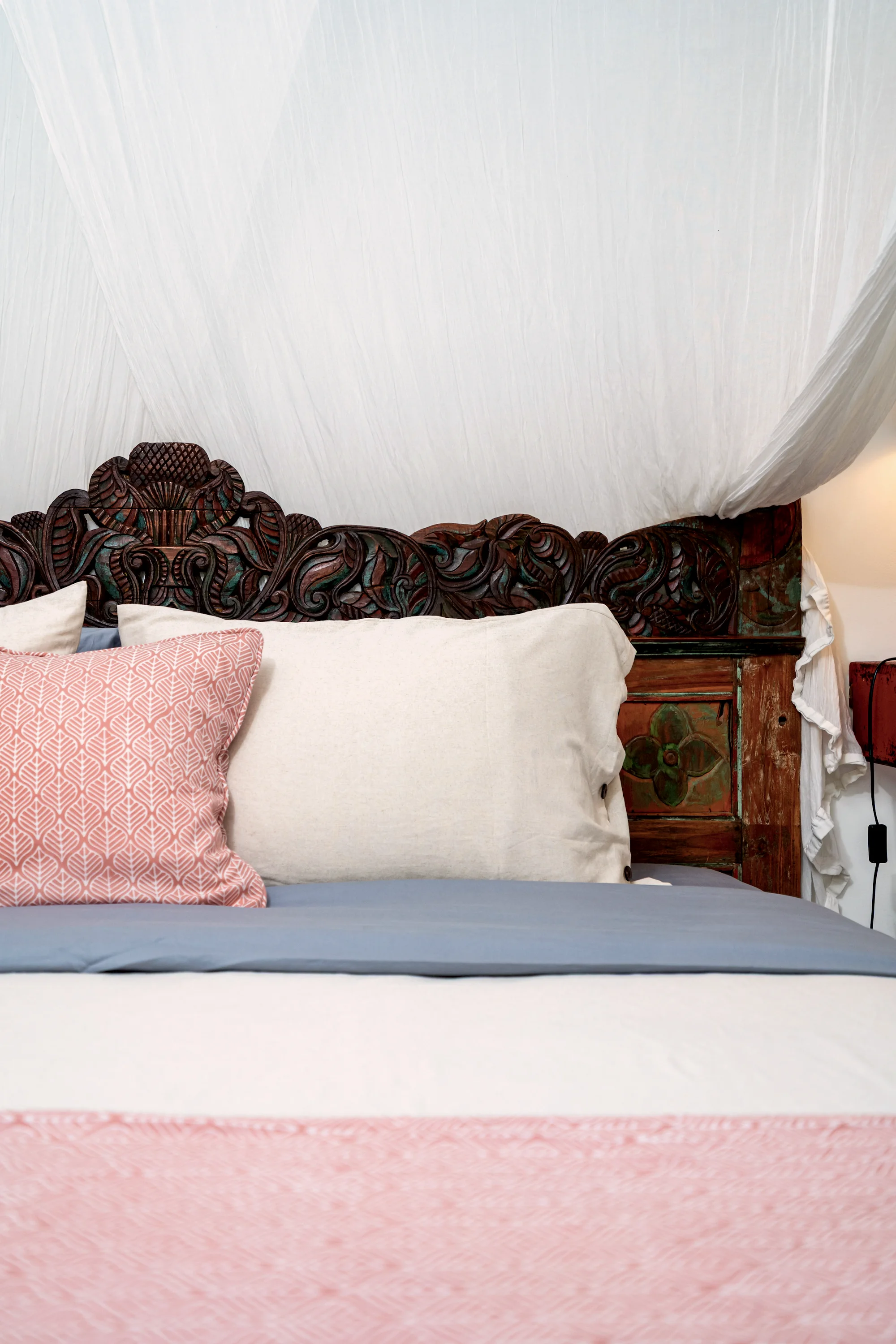 The carved teak headboard of the master bed