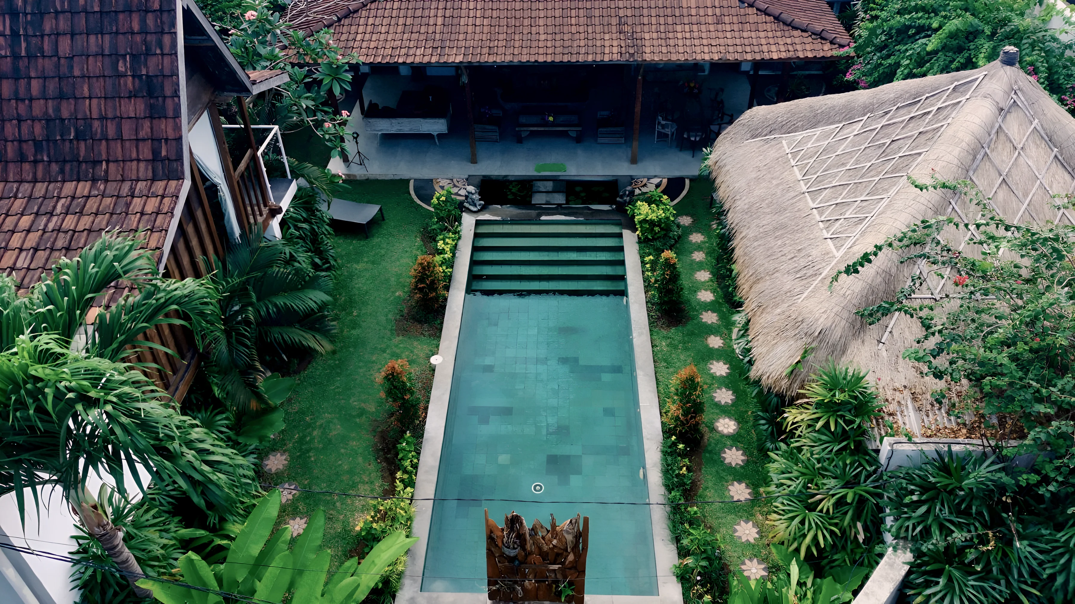 The villa from above: the pool, the living pavilion, the thatched bale and the garden