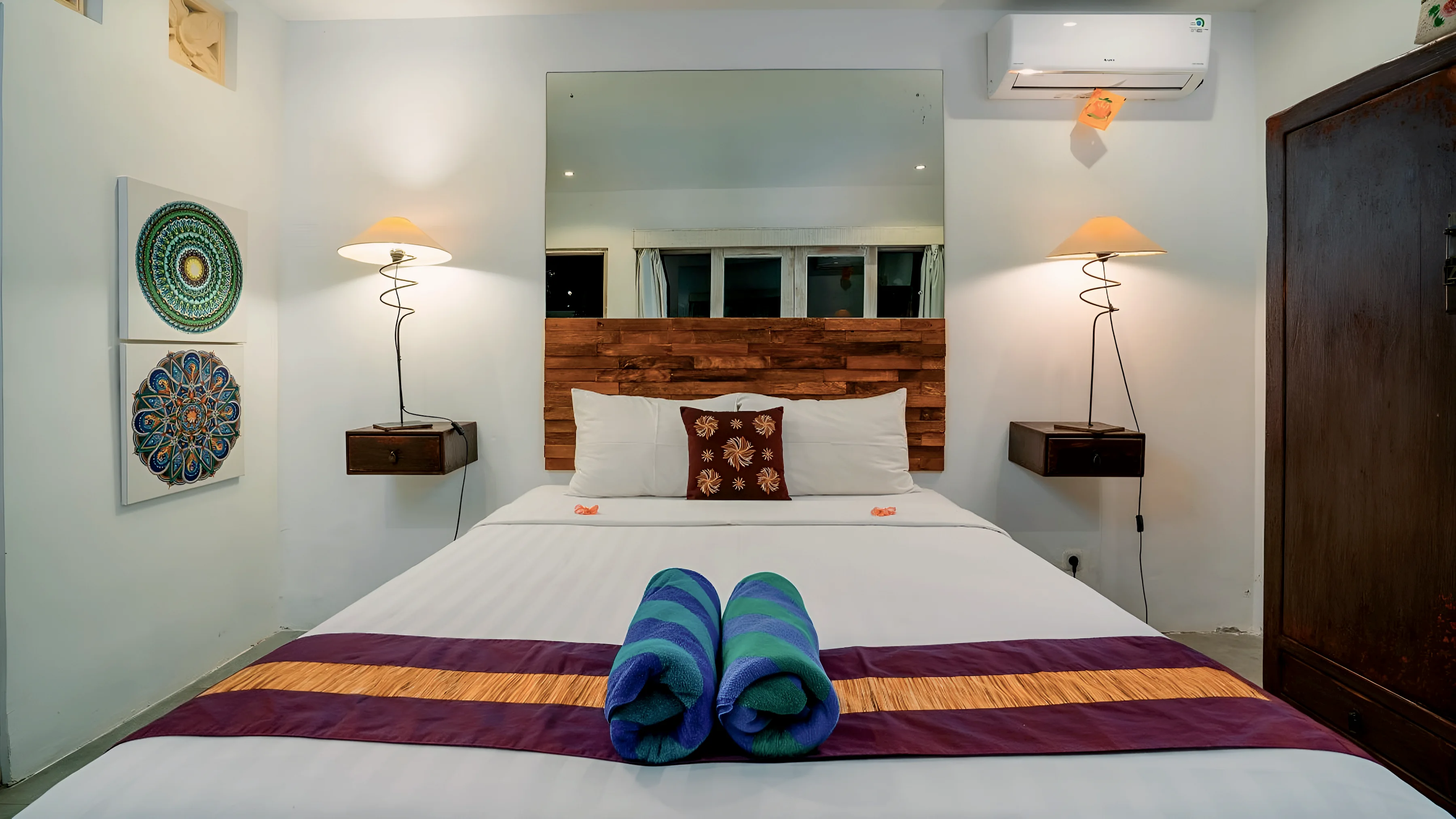 A double bed with a reading lamp on each side