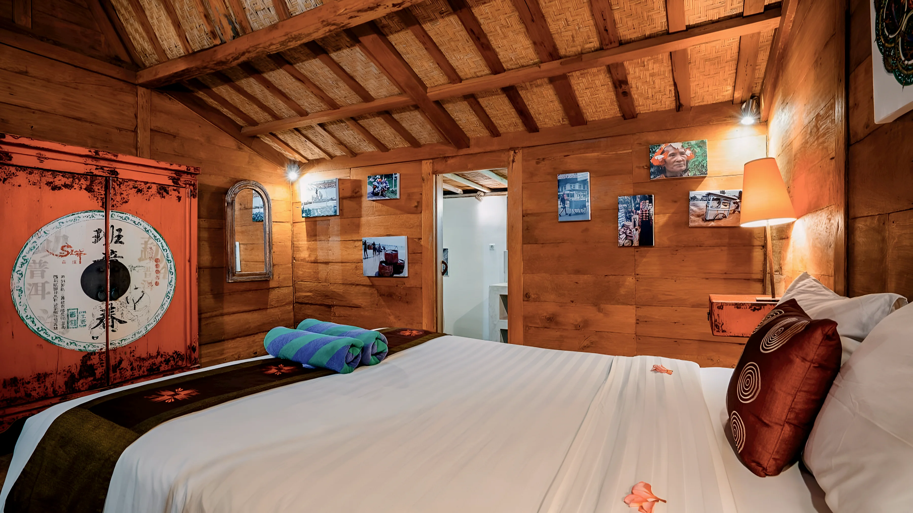 A Joglo bedroom with a red lacquered cabinet beside the bed